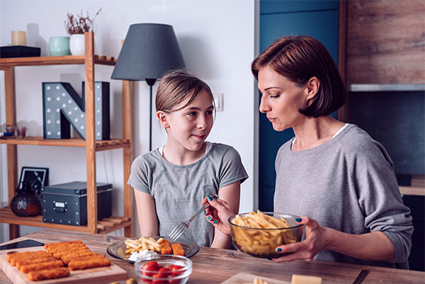 mom and daughter preparing dinner