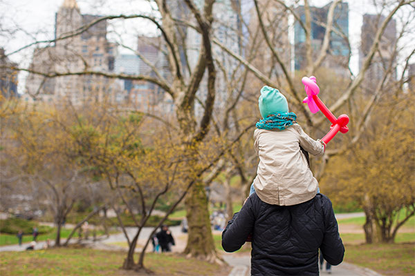 father and daughter walking thru central park