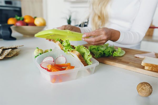 lunch in container with carrots and sandwich