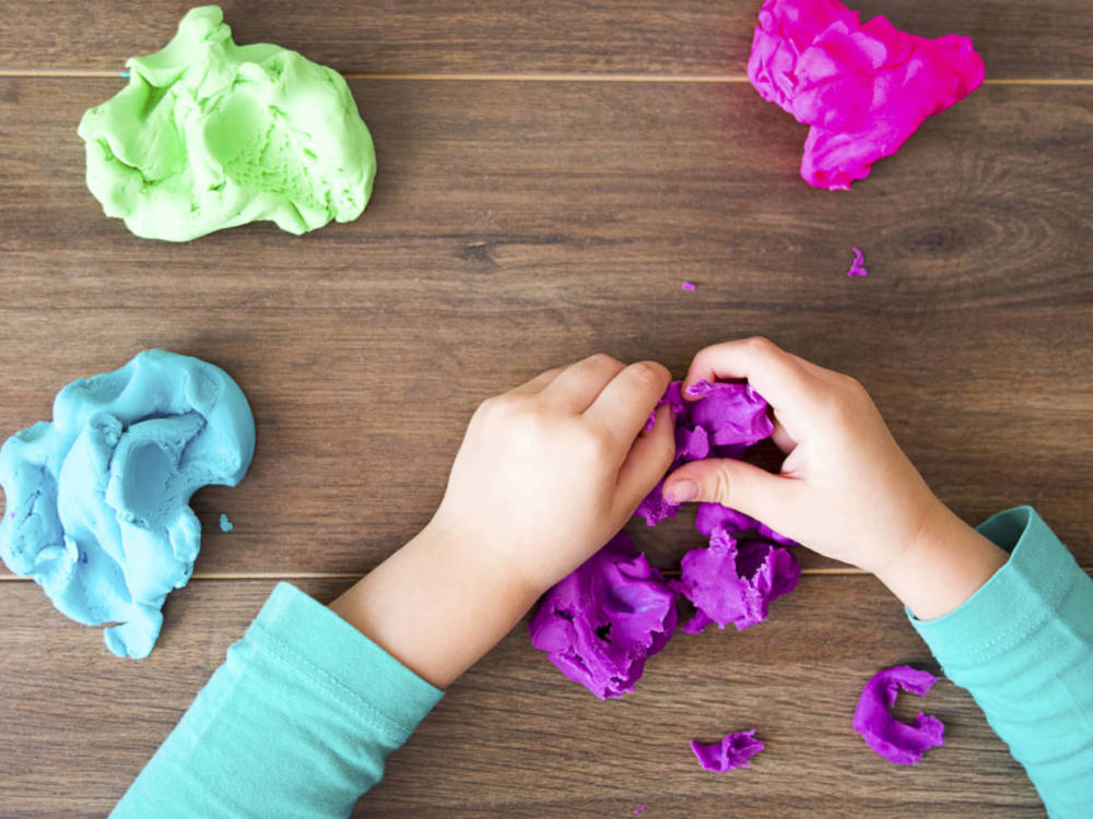 kid playing with colored clay